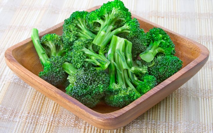 A wooden bowl of fresh, steamed broccoli.